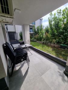 a patio with chairs and a table and a window at Apartament SUPERB in regim Hotelier- Arad Plaza in Arad