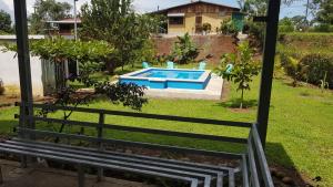 a bench in a yard with a swimming pool at Casa para vacacionar Family in Chachagua