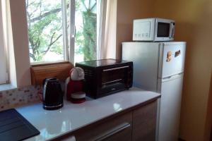 a kitchen with a microwave on top of a refrigerator at Duplex at the foothills of the Pyrenees in Geu
