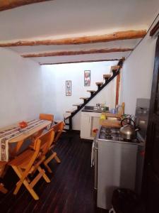una cucina con scala, tavolo e sedie di Asiriq Wasi Guest House a Cuzco