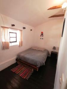 una camera da letto con un letto con un cappello a Babbo Natale sul muro di Asiriq Wasi Guest House a Cuzco