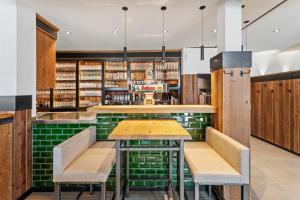 a bar with green tile and wooden tables and chairs at Köhlerei am See in Feldberg