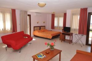 a living room with a bed and a red couch at Elia Studios in Skala Marion