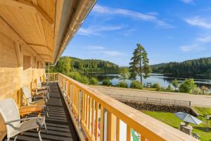 a balcony with chairs and a view of a lake at Köhlerei am See in Feldberg