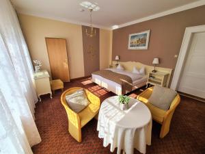 a hotel room with a bed and a table and chairs at Landhotel in Mühltroff