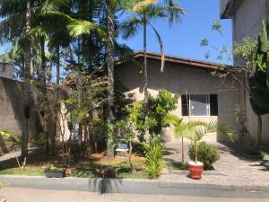 a house with palm trees in front of it at Suites Praia de Pernambuco in Guarujá