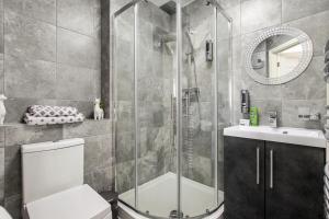 a bathroom with a shower and a toilet and a sink at Ruby Kingsize Bedroom with En-suite in Derby