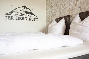 een bed met witte lakens en kussens in een kamer bij Sweet Harmony Apartment mit Seeblick zum Genießen in Hahnenklee-Bockswiese