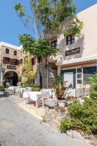 a restaurant with tables and chairs in front of a building at To Rodi Apartments in Rhodes Town