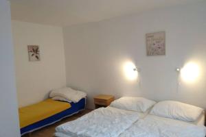 2 camas en una habitación con paredes blancas en HannaH - Relax dom pod orechom I4, en Trávnica