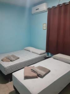 two beds in a room with towels on them at Alvorada Suite in Manaus