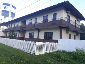 a white house with a fence in front of it at Hotel Araruna in Soure