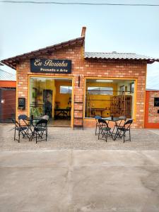 卡兰卡斯Suítes da Eu Florinha的大楼前设有桌椅的餐厅