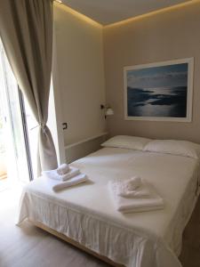 ナポリにあるViola's Homeのベッドルーム1室(白いベッド1台、タオル付)