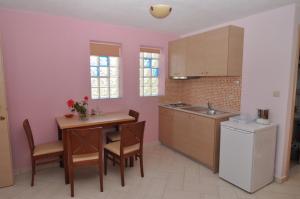 a kitchen with a table and chairs and a refrigerator at Elia Studios in Skala Marion