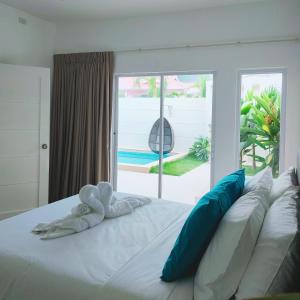 a white bed with blue and white pillows in a bedroom at Pineale Villas, Resort and Spa in Panglao Island