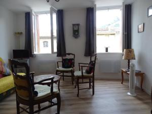 a living room with chairs and windows at Appartement spacieux 6 personnes très lumineux in Buis-les-Baronnies