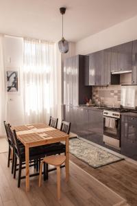 cocina con mesa de comedor de madera y sillas en Sunny Studio Apartment, en Iaşi