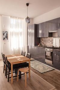 a kitchen with a wooden dining table and chairs at Sunny Studio Apartment in Iaşi