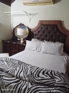 a zebra print bed in a bedroom with a mirror at Barbican cozy Flat at dillsbury in Kingston
