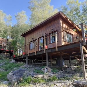 a log cabin in the woods with a deck at Cabaña Sierra in Sierra de los Padres