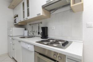 a white kitchen with a stove and a sink at House Mia in Trogir
