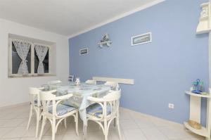 a dining room with a table and white chairs at House Mia in Trogir