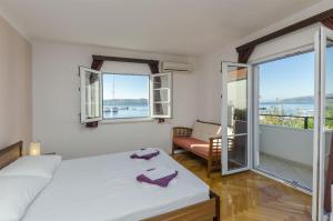 a bedroom with a bed and a balcony with a view at House Mia in Trogir