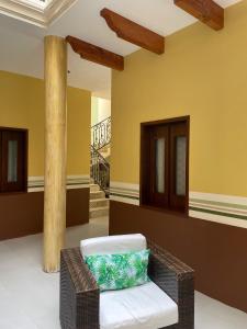 サカテカスにあるHotel Mina Vetagrandeの黄色い壁の客室内に籐の椅子