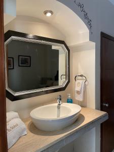La salle de bains est pourvue d'un lavabo et d'un grand miroir. dans l'établissement Hotel Mina Vetagrande, à Zacatecas