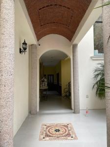 - un couloir d'une maison avec un tapis au sol dans l'établissement Hotel Mina Vetagrande, à Zacatecas