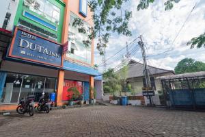 a street with two motorcycles parked in front of a building at RedDoorz @ Komplek Pontianak Mall in Pontianak