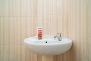a white sink in a bathroom with wooden walls at RedDoorz Syariah near Jalan Ahmad Yani Banjarmasin 3 in Sungai Lutus +50 photos