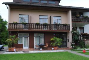 ein Haus mit einem Balkon mit 2 Stühlen und einem Tisch in der Unterkunft Ferienhaus Michor in Latschach ober dem Faakersee
