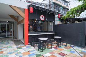 a restaurant with tables and chairs in front of a building at RedDoorz Syariah near Jalan Ahmad Yani Banjarmasin 3 in Sungai Lutus