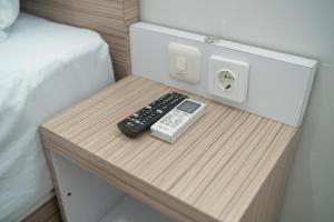 a table with a remote control and a phone on it at RedDoorz Syariah near Jalan Ahmad Yani Banjarmasin 3 in Sungai Lutus