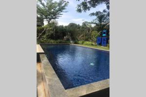 a swimming pool with blue water in a yard at The Pines Vimala Hills in Bogor