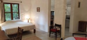a bedroom with a bed and a table and chairs at Isai Ambalam guest house in Puducherry