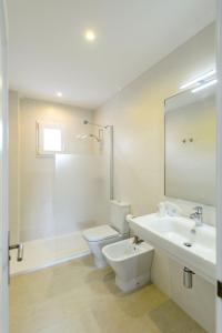 Un baño blanco con inodoro y lavabo. en Lili Apartments, en Puerto de Sóller
