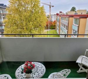 een balkon met een tafel en een vaas met bloemen bij City apartment in Rovaniemi