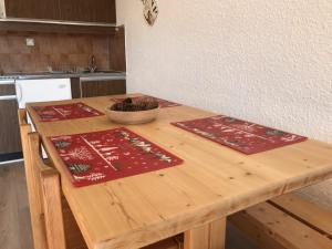 una mesa de madera con 2 colchonetas en la cocina en Studio Corrençon-en-Vercors, 1 pièce, 4 personnes - FR-1-515-99, en Corrençon-en-Vercors