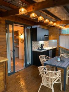 eine Küche und ein Esszimmer mit einem Tisch und Stühlen in der Unterkunft Maison avec piscine chauffée - 8 personnes - Sud Réunion in Saint-Joseph