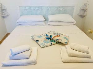 a white bed with towels on it with a bed at Lulù Marin Praia 2 in Praia a Mare