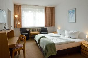 a hotel room with a large bed and a desk at Hotel Harz in Hahnenklee-Bockswiese