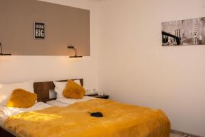 a bedroom with two beds with yellow pillows at Complex Turistic Dávid in Boghiş