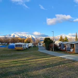 un groupe de terrains de camping avec des montagnes en arrière-plan dans l'établissement Omarama TOP10 Holiday Park, à Omarama