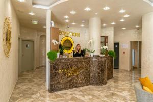 a woman standing at a reception desk in a hotel lobby at Hotel CITY Petrich in Petrich