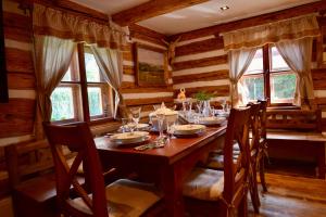 a dining room with a wooden table and chairs at Wellness Roubenka Křižánky in Křížánky
