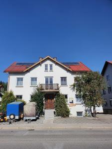 une grande maison blanche avec un toit rouge dans l'établissement Ferienwohnung Dilara, à Immenstadt