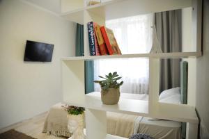 ein weißes Bücherregal mit einer Topfpflanze darauf. in der Unterkunft Cozy Apartment Center in Chişinău
